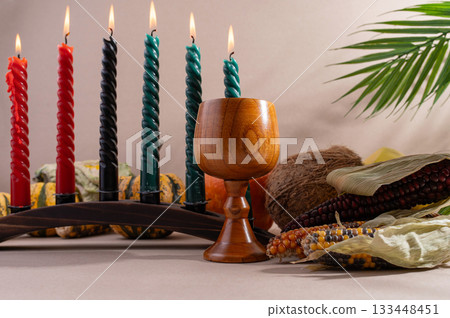 Happy Kwanzaa. Seven candles red, black and green on a natural wooden background. Harvest and gifts. Symbols of African heritage. Happy Kwanzaa. Seven candles red, black and green on a natural wooden background. Harvest and gifts. Symbols of African heritage. 133448451