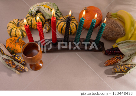 Happy Kwanzaa. Seven candles red, black and green on a natural wooden background. Harvest and gifts. Symbols of African heritage. Happy Kwanzaa. Seven candles red, black and green on a natural wooden background. Harvest and gifts. Symbols of African heritage. 133448453