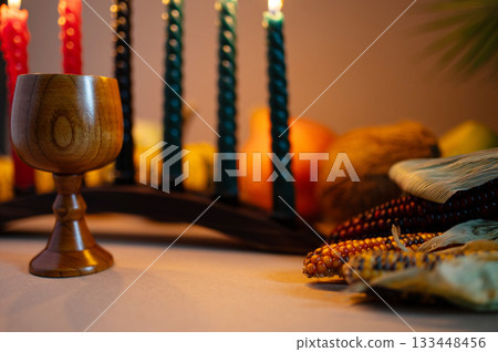 Happy Kwanzaa. Seven candles red, black and green on a natural wooden background. Harvest and gifts. Symbols of African heritage. 133448456