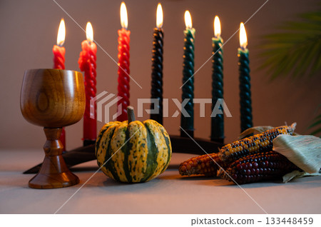 Happy Kwanzaa. Seven candles red, black and green on a natural wooden background. Harvest and gifts. Symbols of African heritage. Happy Kwanzaa. Seven candles red, black and green on a natural wooden background. Harvest and gifts. Symbols of African heritage. 133448459