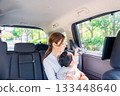 Mother with child fastening seat belt in taxi 133448640
