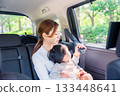 Mother with child fastening seat belt in taxi 133448641