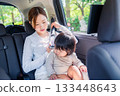 Mother with child fastening seat belt in taxi 133448643