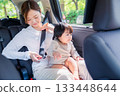 Mother with child fastening seat belt in taxi 133448644