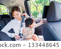Mother with child fastening seat belt in taxi 133448645
