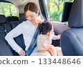 Mother with child fastening seat belt in taxi 133448646