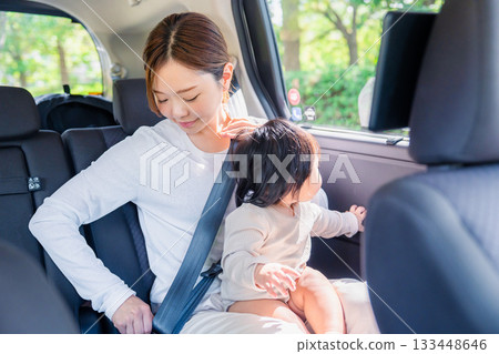 Mother with child fastening seat belt in taxi Mother with child fastening seat belt in taxi 133448646