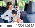 Mother with child fastening seat belt in taxi 133448648