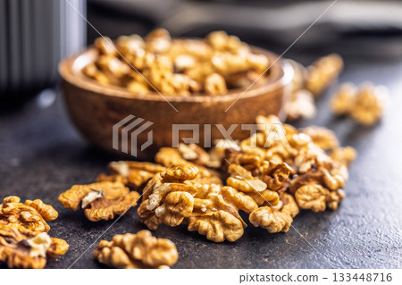 Peeled walnut kernels on black table. Peeled walnut kernels on black table. 133448716