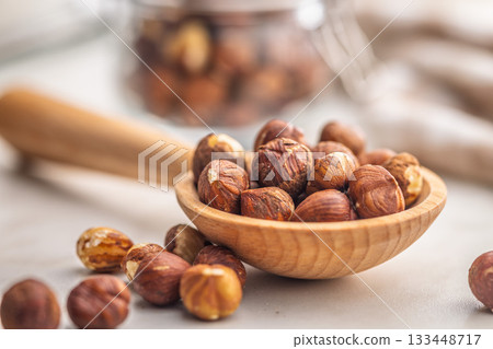 Peeled hazelnut kernels on wooden spoon on kitchen table. Peeled hazelnut kernels on wooden spoon on kitchen table. 133448717