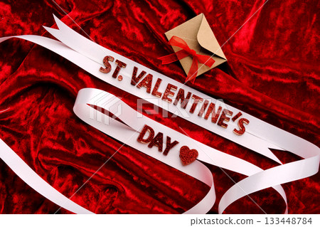 Festive background with the words St. Valentine's Day with red velvet and white ribbon. 133448784