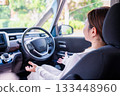 A young woman driving a self-driving car 133448960