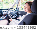 A young woman driving a self-driving car 133448962