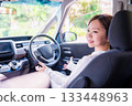 A young woman driving a self-driving car 133448963