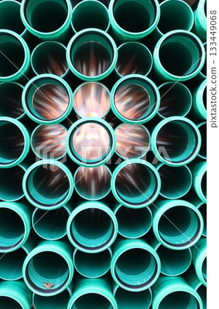 Abstract view of green plastic pipes stacked together Abstract view of green plastic pipes stacked together 133449068