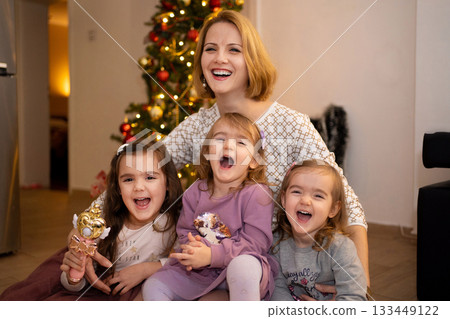 Joyful holiday gathering with family around a festive tree Joyful holiday gathering with family around a festive tree 133449122