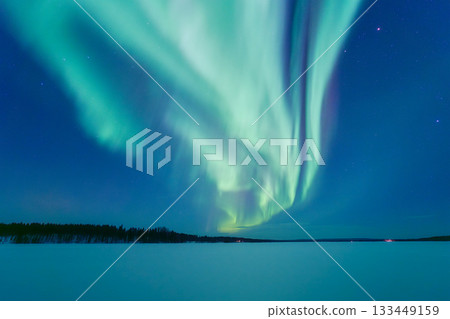 Aurora Borealis in Scandinavia. Northern lights over frozen lake and forest. Starry sky. Aurora Borealis in Scandinavia. Northern lights over frozen lake and forest. Starry sky. 133449159