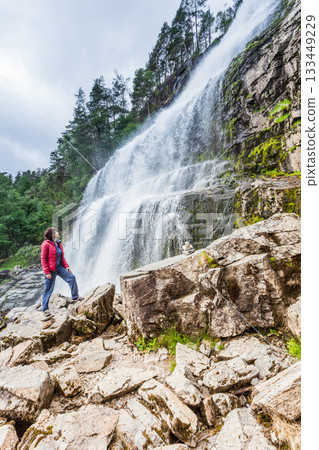 Tourist woman at waterfall Svandalsfossen, Norway Tourist woman at waterfall Svandalsfossen, Norway 133449229