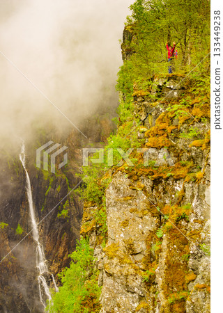 Tourist woman by Voringsfossen waterfall, Norway 133449238