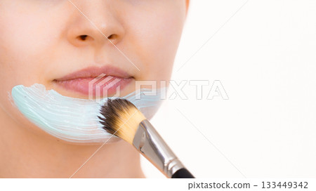 Girl apply green mud mask to face Girl apply green mud mask to face 133449342