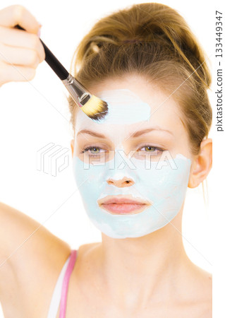 Girl apply green mud mask to face 133449347