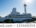 The Ship Science Museum building with its white walls and orange observation deck under the bright blue sky and dazzling sunlight 133449359