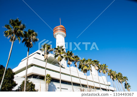 The Ship Science Museum building with its white walls and orange observation deck under the bright blue sky and dazzling sunlight 133449367