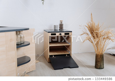 Wooden toy kitchen cabinet with open shelves and drop down door in modern interior 133449386