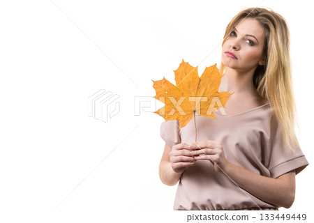 Woman holding maple leaf in hand Woman holding maple leaf in hand 133449449