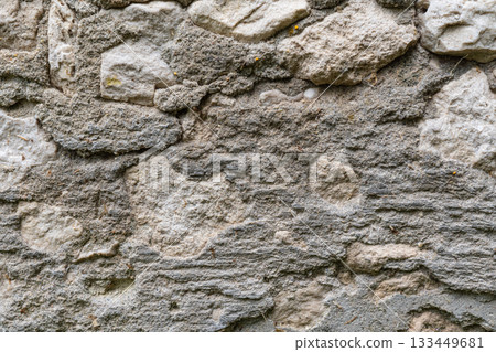 Textured stone wall with rough surface and varied rock patterns Textured stone wall with rough surface and varied rock patterns 133449681