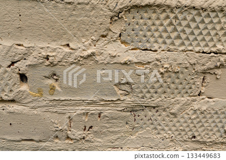 Textured beige painted brick wall with patterned surface detail 133449683
