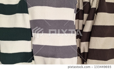 Top view of folded striped and solid knit sweaters Top view of folded striped and solid knit sweaters 133449693