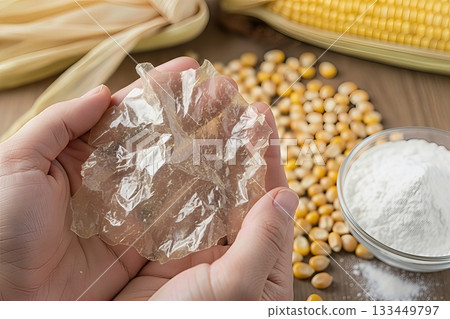 Close-up shot of hands holding a transparent, compostable bioplastic film made from corn starch Close-up shot of hands holding a transparent, compostable bioplastic film made from corn starch 133449797
