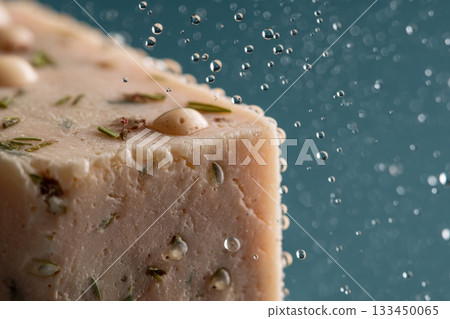 Close-Up of a Natural Soap Bar with Water Droplets, Highlighting Its Texture and Ingredients on a Soft Blue Background 133450065