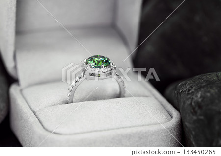 A green and white ring is in a white box 133450265