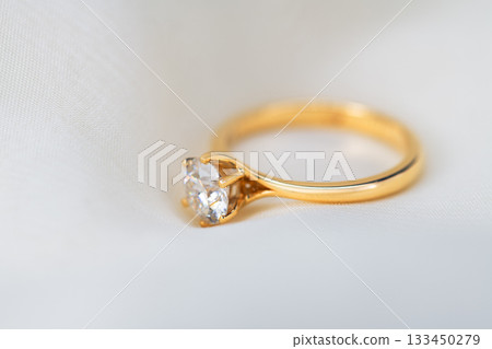 A gold ring with a diamond in the center 133450279