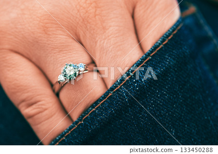 A person is wearing a ring with three stones on it A person is wearing a ring with three stones on it 133450288