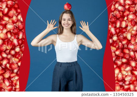 Beautiful young happy woman holding pomegranate fruit on her head 133450325
