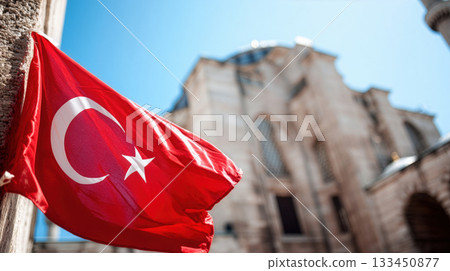 Turkish flag waves in front of historic architecture under a clear blue sky in Istanbul 133450877