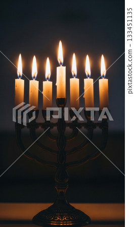 A seven-branched menorah with lit candles glowing warmly against a dark background. The scene evokes a spiritual, peaceful, and traditional mood. Ideal for religious or holiday content. 133451135