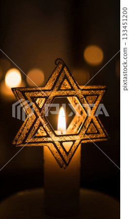 A close-up of a Star of David ornament illuminated by a single candle flame. The warm, glowing light creates a spiritual and peaceful mood. Ideal for Hanukkah or memorial concepts. A close-up of a Star of David ornament illuminated by a single candle flame. The warm, glowing light creates a spiritual and peaceful mood. Ideal for Hanukkah or memorial concepts. 133451200