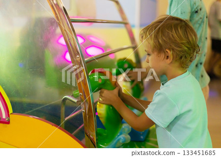 Child Enjoying Arcade Game with Colorful Lights 133451685