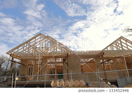 Affordable housing wooden frame construction.New residential building framed with wood, illustrating fast and cost-effective home development amid rising housing demand and affordability challenges. Affordable housing wooden frame construction.New residential building framed with wood, illustrating fast and cost-effective home development amid rising housing demand and affordability challenges. 133452946