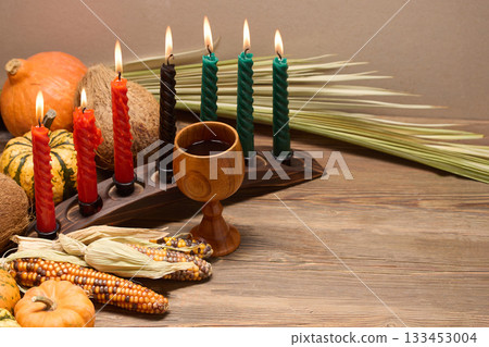 Kwanzaa Table Setting. A Kwanzaa display with lit candles, maize, and decorative pumpkins Kwanzaa Table Setting. A Kwanzaa display with lit candles, maize, and decorative pumpkins 133453004