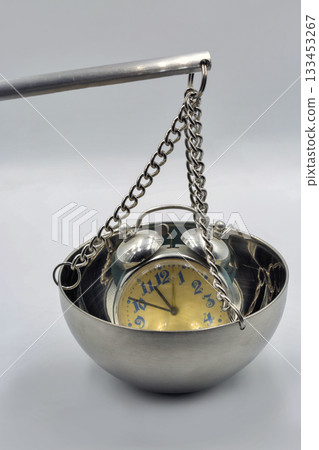 Alarm clock on metal balance scale closeup. 133453267