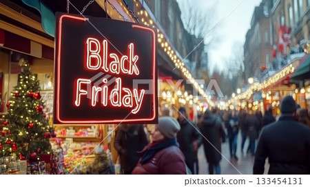 Black Friday sign hangs above busy shopping street with festive lights. Concept of holiday shopping and sales. For seasonal sale promotions 133454131