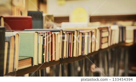 Pile of vintage books on table in store. Books arranged on wooden shelf with vintage look and shallow depth of field. Book collection, literature archive. Education, hobby, reading concept Pile of vintage books on table in store. Books arranged on wooden shelf with vintage look and shallow depth of field. Book collection, literature archive. Education, hobby, reading concept 133454394
