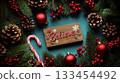 Wooden sign with "Believe" among pine branches, cones, red baubles, and candy cane. Concept of festive holiday decor. For holiday greeting card. 133454492