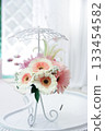 Pastel pink and white gerberas form a delicate bouquet mounted on a slender white wrought iron stand Pastel pink and white gerberas form a delicate bouquet mounted on a slender white wrought iron stand 133454582