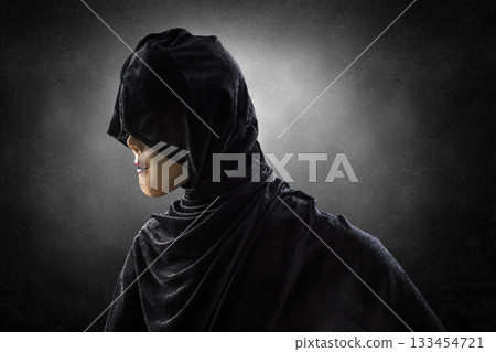 Scary lady with hooded cloak in the dark 133454721